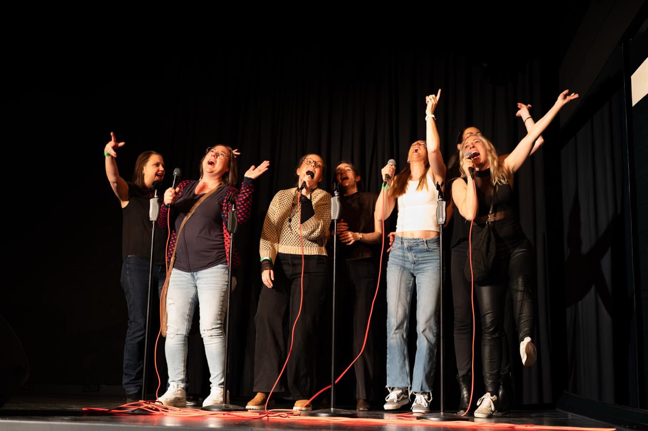Sechs Sängerinnen feiern gemeinsam auf der Karaoke-Bühne